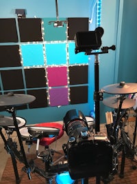 a room with a drum set and a camera