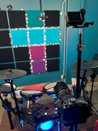 a recording studio with a drum set and a camera