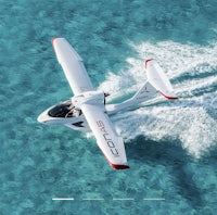 an aerial view of a small plane flying through the water