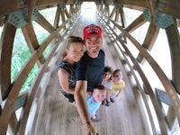 a family is taking a selfie on a wooden bridge