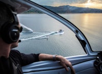 a man in a helicopter looking out over a body of water