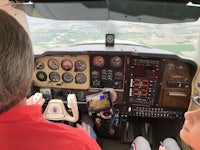 a man and a child sitting in the cockpit of a plane