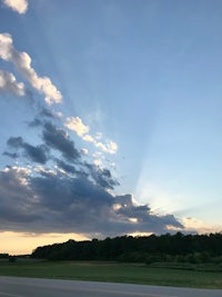 the sun is shining through the clouds over a highway