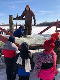 a group of children standing around an ice sculpture