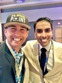 two men posing for a photo in a conference room