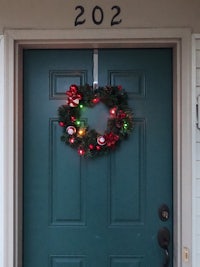 a christmas wreath hangs on the front door of a house